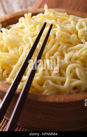 Les nouilles aux oeufs ramen macro dans un bol en bois sur la table verticale. Banque D'Images