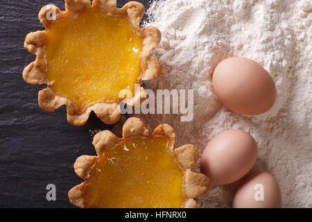 Tarte aux oeufs classique et les ingrédients sur la table close-up Vue de dessus horizontale. Banque D'Images