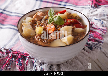 Soupe maison de lentilles brunes avec le poulet et les légumes sur la table horizontale. Banque D'Images