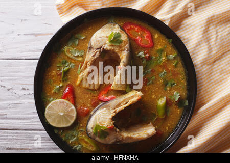 Délicieux curry de poisson épicé de coriandre close up sur la table. vue horizontale d'en haut Banque D'Images