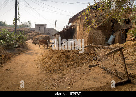 Village de l'Inde rurale avec des bovins, de la boue des maisons avec un village lit bébé dans la cour. Banque D'Images