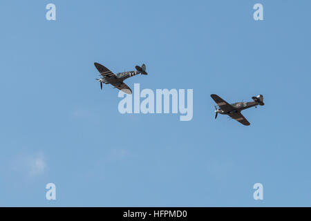 Vintage Supermarine Spitfire et le Hawker Hurricane aéronefs portant sur un fond de ciel bleu à l'Airshow de Southport Banque D'Images