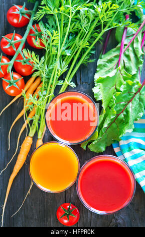 Jus de légumes frais dans le verre et sur une table Banque D'Images