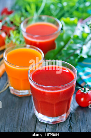 Jus de légumes frais dans le verre et sur une table Banque D'Images