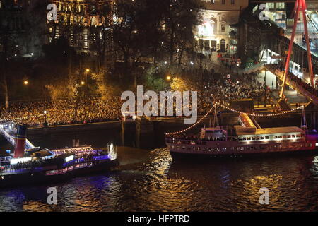 Les foules se rassemblent sur le Victoria Embankment, dans le centre de Londres en tant qu'elles attendent pour entrer dans l'année et regarder le feu d'artifice des célébrations. Banque D'Images