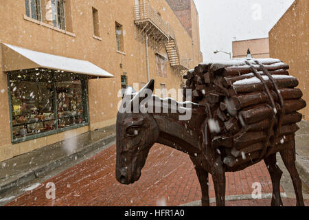 Une sculpture d'un âne marque l'entrée de Burro Alley une fois connu pour les maisons closes et les saloons de l'ouest au cours d'un hiver neige à Santa Fe, Nouveau Mexique. Avant d'automobiles presque tous les biens ont été transportés dans la ville de montagne par des animaux de bât. Banque D'Images