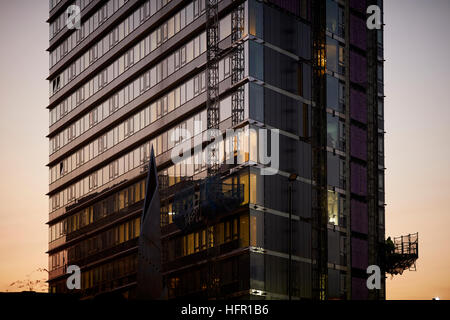 Bâtiment de bureaux couverts échafaudages mécaniques Coucher du soleil lever du soleil au crépuscule à l'aube nuit sombre soirée de travail de construction extérieurs en restauration Banque D'Images