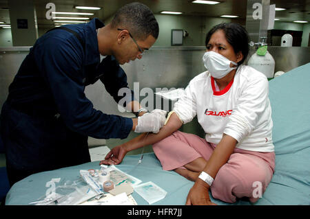 060612-N-3714J-085 Tawi Tawi, Philippines (12 juin 2006) - Navy Hospital Corpsman Vicente Mendes, de Brooklyn, N.Y., prépare un patient pour un IV ayant avant la chirurgie à bord de l'armée américaine Commande de transport maritime (CSM) navire-hôpital USNS Mercy (T-AH 19), alors que le navire de la ville sur une mission humanitaire. La Miséricorde s'est déjà rendue à Zamboanga et Jolo, aux Philippines, où son équipage avait traité plusieurs milliers de patients. Le navire mettra les patients à bord où ses médecins va effectuer des opérations pour enlever goitres et des cataractes ainsi que réparer une fissure des lèvres. À terre, les équipes de d Banque D'Images