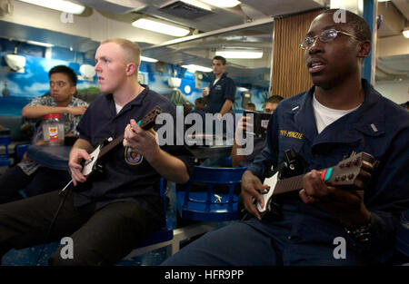 060902-N-9851B-011 de l'océan Pacifique (sept. 2, 2006) - Spécialiste culinaire Seaman Damien McCullough, gauche et Lt J.G. Levy-Minzie jouer une guitare électrique jeu vidéo sur le gâchis de pont à bord du destroyer lance-missiles USS Hopper (DDG 70) au cours de jeu 'night'. Hopper est homeported dans Pearl Harbor, à Hawaï, et est sur un déploiement prévu des opérations de sécurité maritime et de la guerre mondiale contre le terrorisme. U.S. Navy photo by Mass Communication Specialist 2e classe John L. Beeman (libéré) US Navy 060902-N-9851B-011 Spécialiste culinaire Seaman Damien McCullough, gauche et Lt J.G. Jouer un Levy-Minzie Banque D'Images