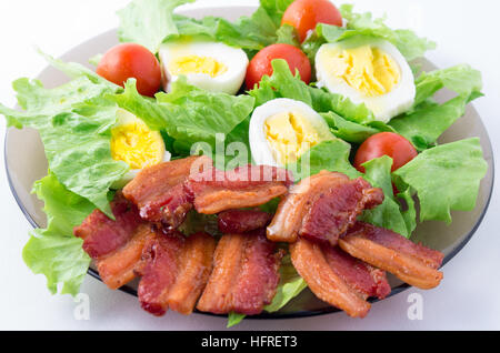 Laitue, tomates cerises, du bacon et des œufs sur une plaque close-up avec une faible profondeur de champ Banque D'Images