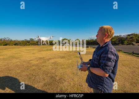 Un homme aux commandes d'un drone dans un parc de Sydney, Australie Banque D'Images