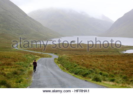 La voie à suivre pour un jeune homme dans un paysage rural à l'ouest de l'Irlande Banque D'Images