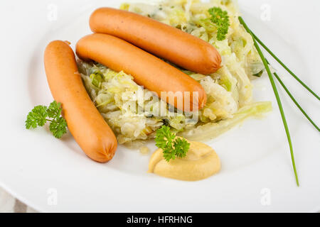 Trois mini-saucisses sur le chou frit avec de la moutarde, Close up Banque D'Images