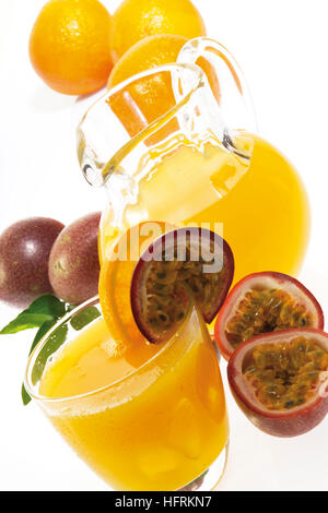 Verseuse et verre de jus de fruit de la passion-orange avec des oranges fraîches et de fruits de la passion Banque D'Images