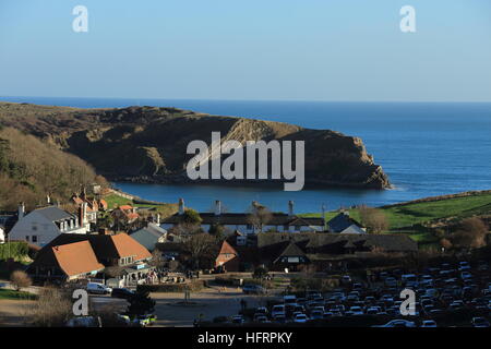 Lulworth Cove de la position relevée sur un hiver clair après-midi vue de la géologie de la roche. village et crique. Destination de vacances populaire à Dorset. Banque D'Images