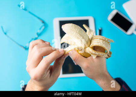 Peeling une banane mâle part à l'œuvre dans le bureau Banque D'Images