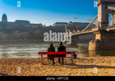 Couple de touristes jeunes bénéficiant d'un beau jour d'hiver à Budapest près du Pont des Chaînes. Banque D'Images