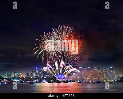 Rouge lumineux boules de feu d'artifice à Sydney pendant la célébration du Nouvel An sur Harbour City CBD de tours et de points de repère. Banque D'Images