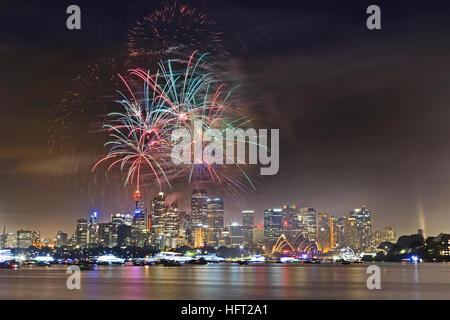 D'artifice nouvel an dans les eaux du port de Sydney CBD de la ville au-dessus de plusieurs couleurs lumineuses - boules de feu dans le ciel. Banque D'Images