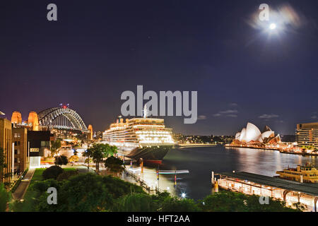 L'heure du coucher du soleil sombre avec pleine lune au-dessus de Sydney Harbour Bridge, de l'outre-mer, terminal de passagers et Circular Quay Ferry Pier lorsque disponible sites touristiques de la ville sont accessibles Banque D'Images