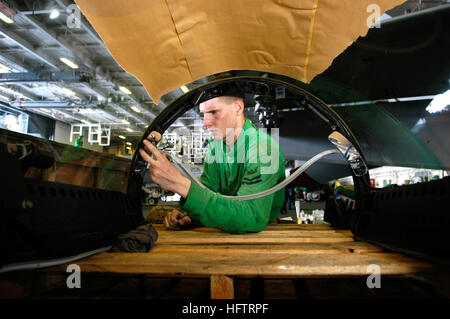 050728-N-3136P-012 de l'océan Pacifique (28 juillet 2005) - mécanique des structures de l'Aviation 2e classe Vonszilassy Equipmentman Peter, installe des miroirs sur un cockpit F/A-18F Super Hornet's écran du vent à l'intérieur du hangar Bay à bord de l'USS Kitty Hawk (CV 63). Six miroirs de pilotage aviateurs aide élargir leur vision pendant le vol le fonctionnement. En ce moment en cours dans la 7e flotte zone de responsabilité (AOR), le porte-avions à propulsion conventionnelle montre la projection de puissance et de contrôle de la mer comme la marine de façon permanente que l'avant-porte-avions déployés. U.S. Navy photo by Photographer's Mate Airman Jimmy C. Pan Banque D'Images