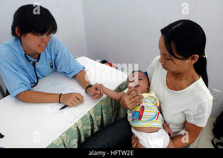 070717-N-9421C-015 Da nang, Vietnam (17 juillet 2007) - Le Cmdr. Con Yee Ling traite de l'état d'un bébé à sa mère à Ngu Hanh Son District Medical Center à Da nang, Vietnam. Ce projet d'action civile médicale est l'un des nombreux cours dans la région du Pacifique à l'appui du partenariat, une étude de quatre mois de mission d'assistance humanitaire dans la région. U.S. Navy photo by Mass Communication Specialist 2e classe Kerryl Cacho (libéré) US Navy 070717-N-9421C-015 le Cmdr. Con Yee Ling traite de l'état d'un bébé à sa mère à Ngu Hanh Son District Medical Center à Da nang, Vietnam Banque D'Images