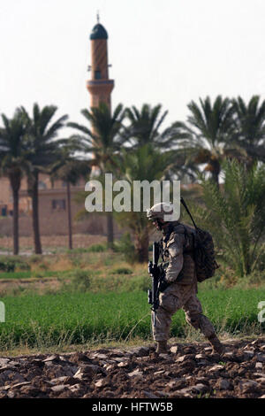 060811-M-9019H-080 Haditha, l'Irak (16 août 2000 11, 2006) - lance le Cpl. Wyatt C. Zimminger de Gainesville, Floride, affecté à de l'Inde 3e Compagnie 3e bataillon de marine (3/3) les positions ennemies patrouilles après avoir pris feu dans une palmeraie. L'équipe de combat régimentaire 3/3 sept est déployée avec I Marine Expeditionary Force (avant) à l'appui de la guerre mondiale contre le terrorisme dans la province d'Al Anbar en Irak. Les forces américaines travaillent avec les forces de sécurité irakiennes, afin de faciliter l'élaboration de la règle de droit par un gouvernement démocratique. U.S. Marine Corps photo par le Cpl. Brian M Henner (libéré) US Navy 0608 Banque D'Images