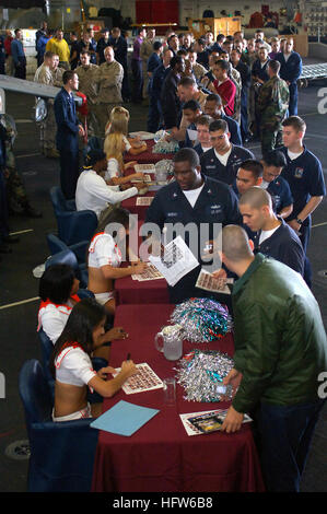 Les Miami Dolphins cheerleaders et Stanley Wilson, pour les Lions de Détroit évoluait, signer des autographes dans la zone de l'assaut amphibie USS Tarawa au cours d'une visite de l'USO. Le groupe expéditionnaire Tarawa est affecté à la 5e flotte zone de responsabilité dans le cadre d'un déploiement prévu. (U.S. Photo de la marine/matelot-chef Mike Leporati) Wilson et Miami cheerleaders Banque D'Images