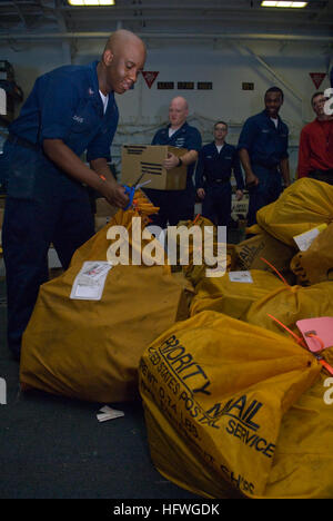 Les commis postaux à bord de l'USS Essex (LHD 2) trient le courrier dans la baie du hangar pendant les opérations de réapprovisionnement en mer de Chine méridionale, soutenant la communication du personnel et la préparation logistique. Banque D'Images