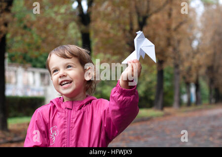 Petite fille tenant une colombe de papier Banque D'Images