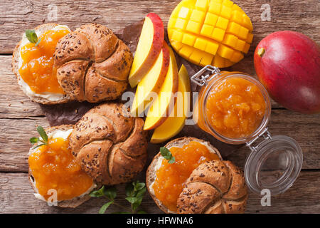 Avec les pains, beurre et confiture de mangue à la menthe décoration fermer vers le haut sur la table. vue horizontale d'en haut Banque D'Images