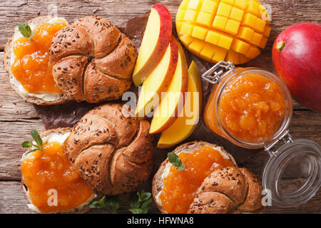 Petit-déjeuner : Sandwiches avec confiture et beurre de mangue douce close-up sur la table horizontale vue du dessus. Banque D'Images