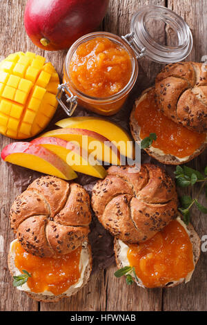 Petit-déjeuner : Sandwiches avec confiture et beurre de mangue douce close-up sur la table. vertical Vue de dessus Banque D'Images