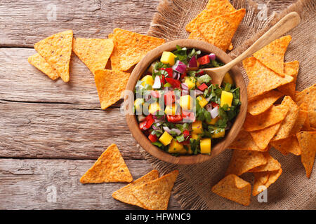 Délicieux avec salsa de mangue, piment fort, la coriandre et l'oignon close up dans un bol et les nachos dans le tableau du dessus horizontale. Banque D'Images