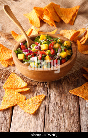 Délicieux avec salsa de mangue, piment fort, la coriandre et l'oignon close up dans un bol et des nachos sur la table. vertical Banque D'Images