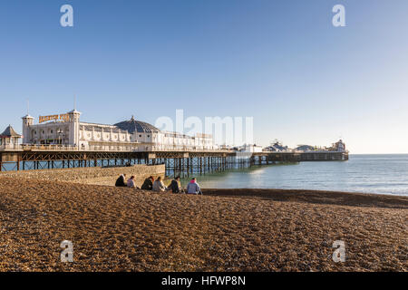 Le Victorian Palace Pier de Brighton Brighton Beach et de galets avec un petit groupe sur un jour d'hiver ensoleillé en novembre avec ciel bleu Banque D'Images