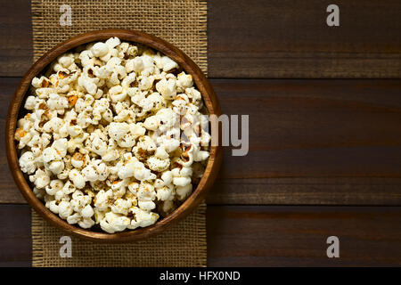 Sarriette fraîche maison du popcorn avec du fromage, l'ail et l'origan séché dans le bol en bois, frais généraux photographié avec une lumière naturelle Banque D'Images