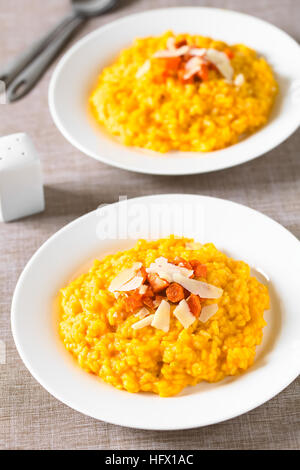 Risotto de carottes fraîches faites maison avec purée de carotte, garnie de carottes rôties et du fromage dur Banque D'Images