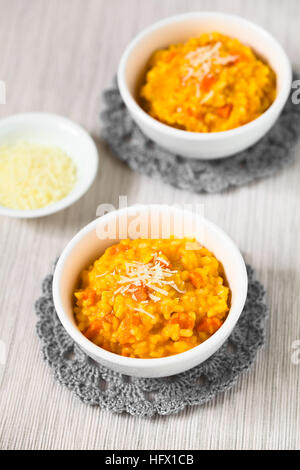 Risotto de carottes fraîches faites maison avec purée de carotte et carotte rôti pièces, garnie de fromage râpé Banque D'Images