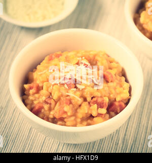 Risotto de carottes fraîches faites maison avec purée de carotte et carotte rôti pièces, garnie de fromage râpé Banque D'Images