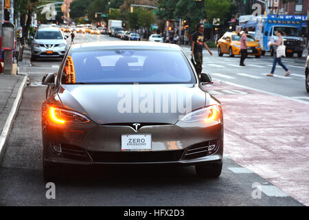 Voiture électrique Tesla avec zéro émission texte sur la plaque d'attente aux feux de circulation Banque D'Images