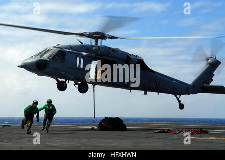 070208-N-0684R-092 de l'océan Pacifique (fév. 8, 2007) - Aviation Boatswain's mates (équipement) sortir de dessous un SH-60 Seahawk affecté à l 'bullets' de l'Escadron d'hélicoptères anti-sous-marin deux trois (HSE-23) après le raccordement d'un filet de retenue du fret à l'hélicoptère à bord du porte-avions de classe Nimitz USS JOHN C. STENNIS (CVN 74). Le John C. Stennis Strike Group (JCSSG) effectue le vol et les opérations du Groupe de grève intégré au large de Guam dans le cadre d'un déploiement de promouvoir la paix, la coopération régionale et de stabilité. U.S. Navy photo by Mass Communication Specialist 3e classe Ron Reeves (REL Banque D'Images