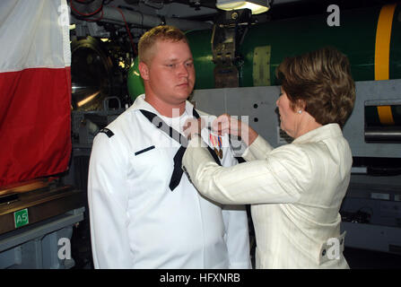 090731-N-3090M-060 Groton (Connecticut) (31 juillet 2009) l'ancienne Première dame Laura Bush et shipÕs parrainer les axes sous-marine terminal, ou ÒdolphinsÓ sur l'uniforme des machinistes Mate 3 classe Christopher Bragg au cours d'une visite de la sous-marin d'attaque USS Texas Virginia-Class (SSN 775). Bush a été un participant à la passation de commandement du Texas plus tard ce jour-là où le Cmdr. Robert Ronscka soulagé la Cmdr. James Gray comme commandant. (U.S. Photo par marine Spécialiste de la communication de masse 1re classe Steven Myers/libérés) US Navy 090731-N-3090M-060 et l'ancienne Première dame Laura Bush, marraine du navire, épingle la submar Banque D'Images