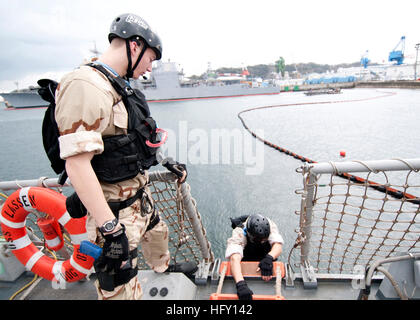 YOKOSUKA, Japon (Janv. 28, 2010) Contrôleur de la circulation aérienne 3 Classe Vince Newell, à gauche, à partir de Detroit, se prépare à débarquer les missiles USS Lassen (DDG 82). Newell est membre de la visite, un conseil, une perquisition et saisie (VBSS) à bord de l'équipe de Lassen. L'équipe VBSS trains sur différentes armes et des procédures d'embarquement afin d'améliorer leurs compétences de compétence lors de l'embarquement et les navires de recherche. (U.S. Photo par marine Spécialiste de la communication de masse de la classe 3ème Devon Dow/libéré) US Navy 100128-N-8721D-001 Contrôleur de la circulation aérienne 3 Classe Vince Newell, à gauche, se prépare à débarquer le d-missiles Banque D'Images