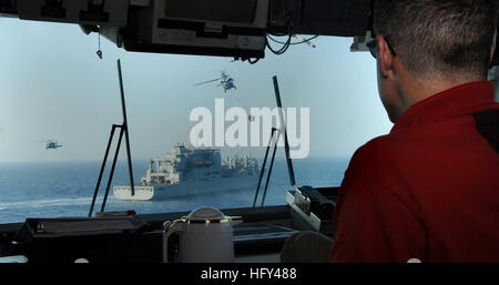 100323-N-7508R-123 mer des Caraïbes (23 mars 2010) Capt Steve Koehler, commandant de l'assaut amphibie polyvalent USS Bataan (DG 5), observe un déchargement de munitions vertical avec la commande de transport maritime de marchandises militaires et munitions ship USNS Lewis et Clark (T-AKE 1) Le 23 mars. Bataan est en train de mener des opérations au large de la côte d'Haïti Appui à l'opération réponse unifiée après un séisme de magnitude 7,0 a causé de graves dommages dans et autour de Port-au-Prince le 12 janvier. (U.S. Photo par marine Spécialiste de la communication de masse 2e classe Julio Rivera/libérés) US Navy 100323-N-7508R-123 Le capitaine S Banque D'Images