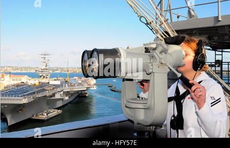 100412-N-8822R-107 SAN DIEGO (12 avril 2010) Spécialiste des opérations Seaman Apprentice Katie Aldridge, de San Antonio, Texas, regarde à travers des jumelles comme classe Nimitz le porte-avions USS Carl Vinson (CVN 70) arrive à son nouveau port d'attache à la Naval Air Station North Island à San Diego. Carl Vinson et Carrier Air Wing 17 a mené l'aide humanitaire et des opérations de secours en Haïti au cours de l'opération réponse unifiée et a tenu des exercices de partenariat avec sept pays d'Amérique latine dans le cadre du sud de la mer de 2010. (U.S. Photo par marine Spécialiste de la communication de masse 3 Classe Antwjuan Richards-J Banque D'Images