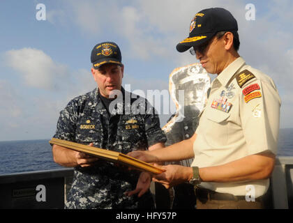 100413-N-8959T-120 DU GOLFE D'ADEN (13 avril 2010) Le Cmdr. Philip Sobeck, commandant de la classe Arleigh Burke destroyer lance-missiles USS Farragut (DDG 99), présente la visite d'état-major de la Défense de Singapour, le général Neo Kian Hong avec une photo commémorative. Une photo de l'NavyÕs shipÕs premier amiral et l'homonyme, Adm. David G. Farragut, est dans l'arrière-plan. Farragut fait partie de la Force opérationnelle combinée 151, une task force multinationale créée pour mener des opérations anti-piraterie dans le golfe d'Aden. (U.S. Photo par marine Spécialiste de la communication de masse 1re classe Cassandra Thompson/libérés) Banque D'Images