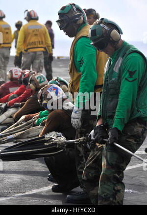 101018-N-7103C-067 de l'OCÉAN PACIFIQUE (oct. 18, 2010) marins tirer la charge du haut sangle d'une barricade en place nette au cours d'une barricade percer à bord du porte-avions USS George Washington (CVN 73). La barricade est utilisé pour capturer avion effectuer un atterrissage d'urgence sur le pont. George Washington, le NavyÕs définitivement que l'avant-porte-avions déployés, est en cours afin d'assurer la sécurité et la stabilité dans l'ouest de l'océan Pacifique. (U.S. Photo par marine Spécialiste de la communication de masse 3e classe David A. Cox/libérés) US Navy 101018-N-7103C-067 marins tirez la sangle de charge supérieur Banque D'Images