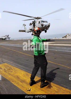 Airman Justin Rankin vérifie que le chemin d'un décollage planant SH-60F Sea Hawk, attribué à l'Chiens poussiéreux de l'Escadron d'hélicoptères anti-sous-marine 7, est libre de personnel et d'équipement de signalisation avant de l'hélicoptère pour quitter le navire. HS-7 est déployée dans le cadre de la Harry S. Truman Strike Group soutenant les opérations de sécurité maritime et les efforts de coopération en matière de sécurité dans le théâtre dans la 5e Flotte des États-Unis zone de responsabilité. (U.S. Photo de la marine/apprenti matelot Tyler Caswell) USS Harry S. Truman DVIDS322883 Banque D'Images