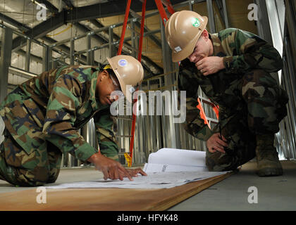 110202-N-2218S-073 Yokosuka, Japon (fév. 2, 2011) Électricien de construction 2e classe Marvin George, à gauche, et en génie aide Constructionman Andrew Chubb, toutes deux affectées à la construction navale (bataillon Mobile NMCB) 11 examen bleus sur un chantier de construction. NMCB-11 est en train de construire une flotte Industrial Supply Center office sur Azuma Island. (U.S. Photo par marine Spécialiste de la communication de masse de la classe 3ème Andrew Ryan Smith/libérés) US Navy 110202-N-2218S-073 électricien de construction 2e classe Marvin George, à gauche, et en génie aide Constructionman Andrew Chubb bleu examen pr Banque D'Images